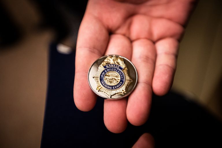 Hand holding KLETC Challenge Coin