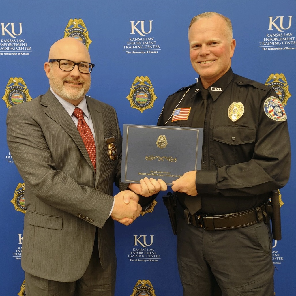 "KLETC Executive Director Darin Beck shales hands with the Class President for the 299th basic training class, Officer Brian Hampton"